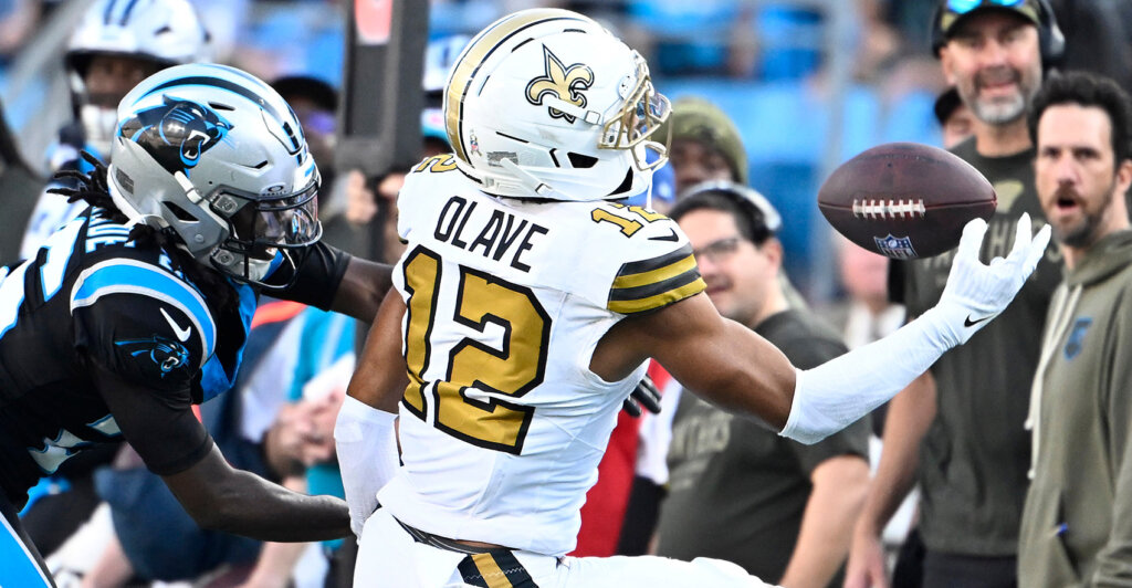 Nov 9, 2025; Charlotte, North Carolina, USA; New Orleans Saints wide receiver Chris Olave (12) makes a one handed catch as Carolina Panthers cornerback Chau Smith-Wade (26) defends in the fourth quarter at Bank of America Stadium. Mandatory Credit: Bob Donnan-Imagn Images